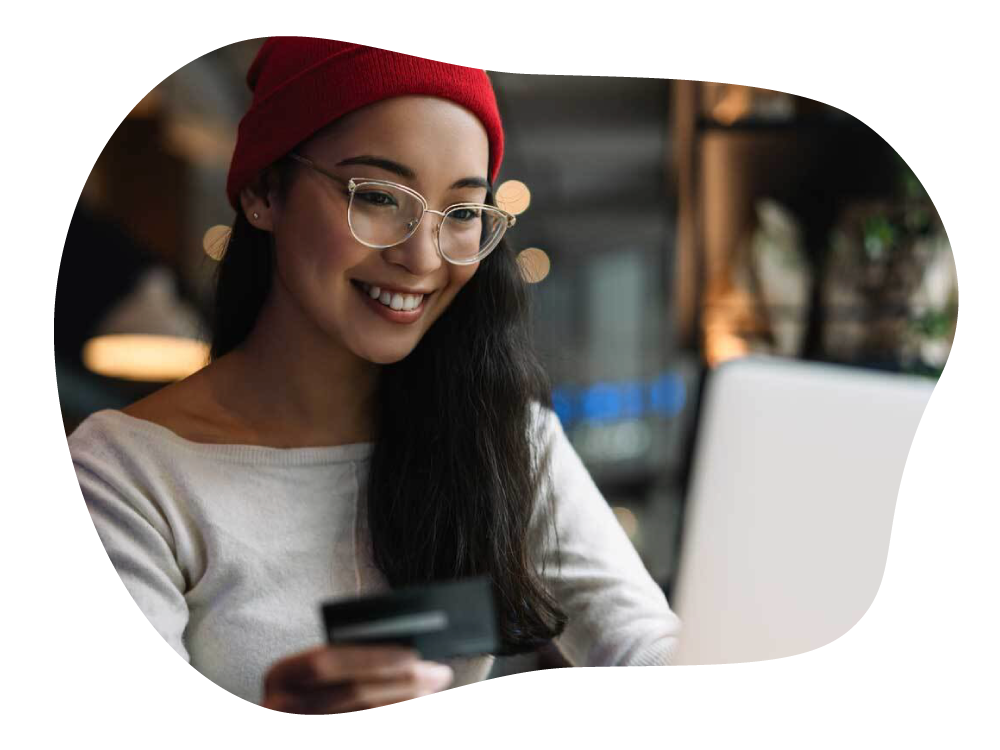 Lady happily making online payment on laptop, with credit card